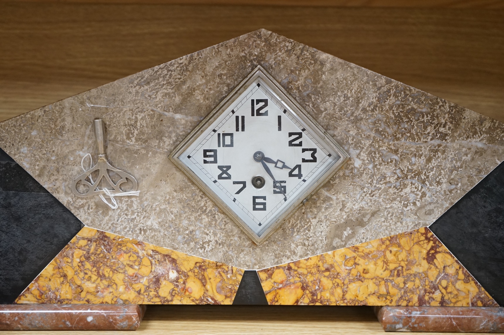 An Art Deco four colour marble clock garniture, with key